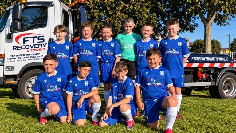 Finglas United Under-11s in their FTS Recovery and Towing sponsored jerseys beside an FTS recovery truck in Finglas West